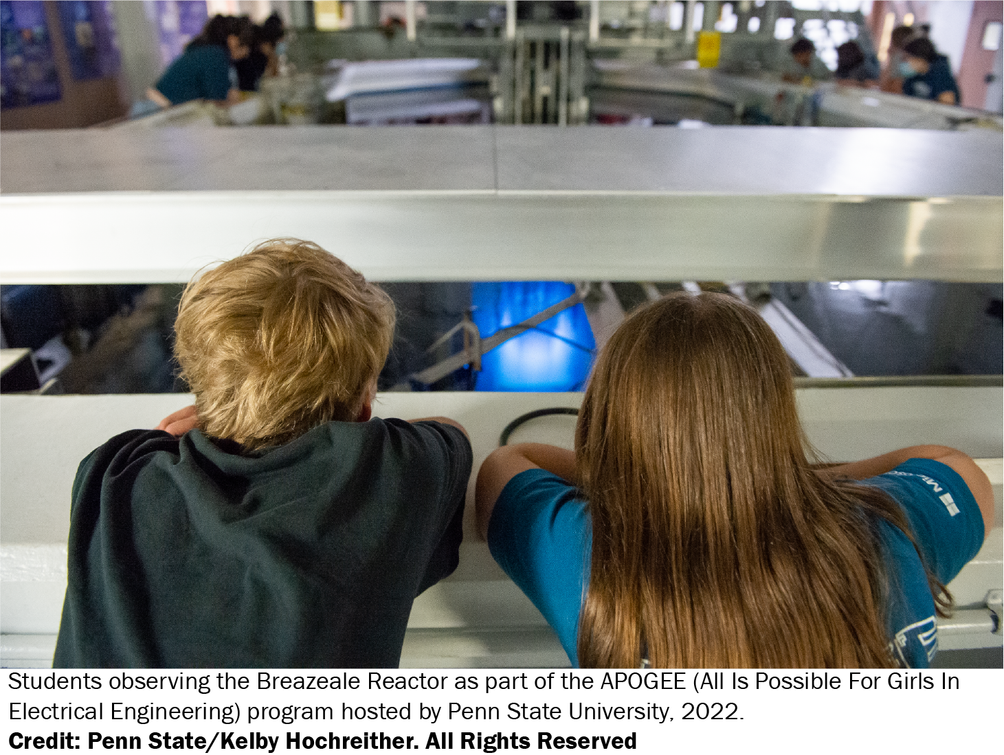 Two students looking on at the nuclear reactor core at Penn State.